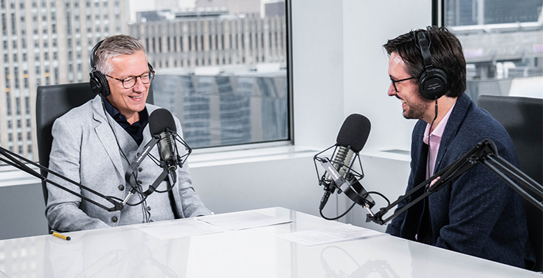 Photography of Paul Ricard and Sean Ringstead talking to each other with radio headphones and microphones.