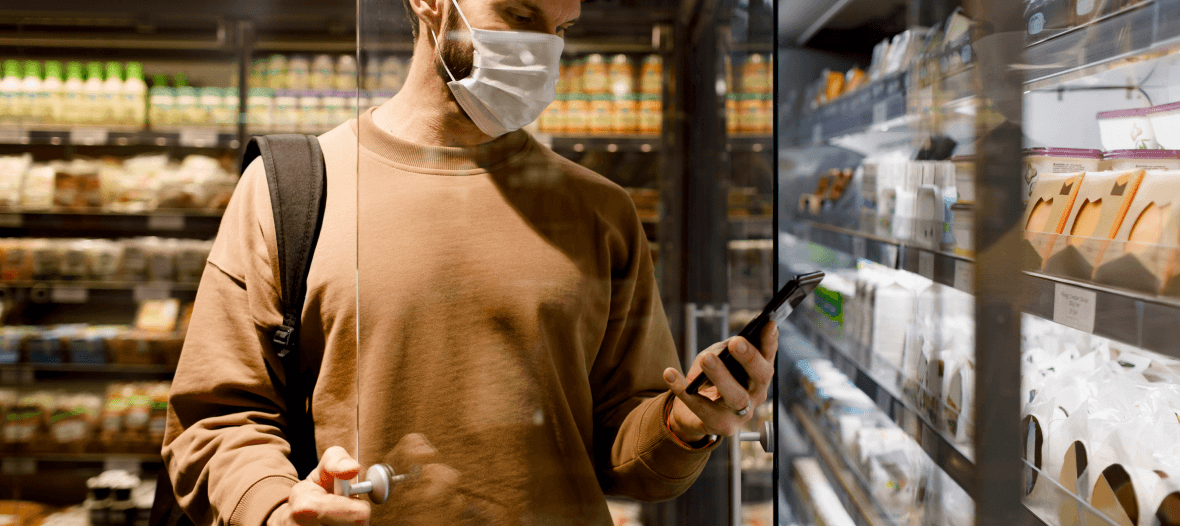 Man checks on a grocery list on his phone at a supermarket