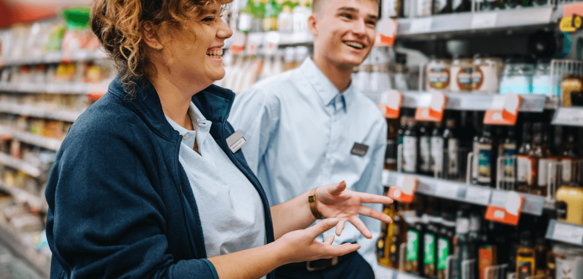 Market staff smiles and talks in a store