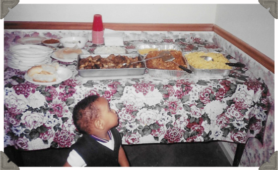 a picture of a toddler looking at a table of food spread