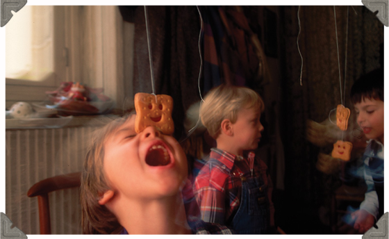 a picture of three children and silly faces with biscuits on their face