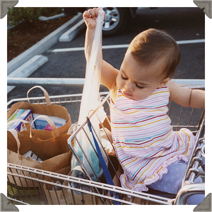 a picture of a toddler on a trolley pulling out grocery