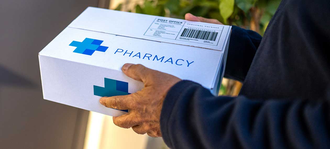 Hands holding a pharmacy box