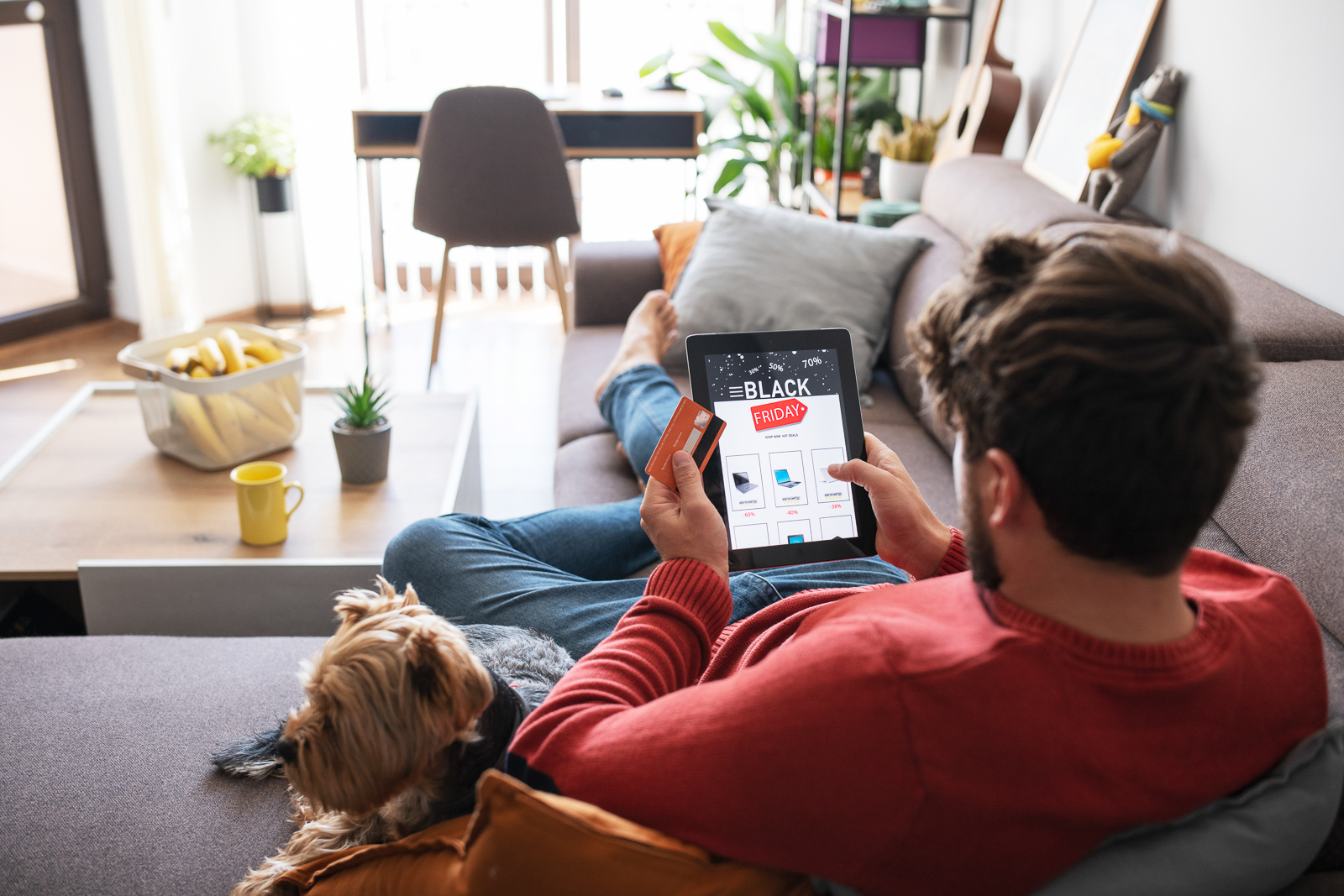 Man laying on couch shopping online