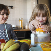 Children pressing oranges to make juice