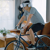 Person riding bike inside with virtual reality goggles