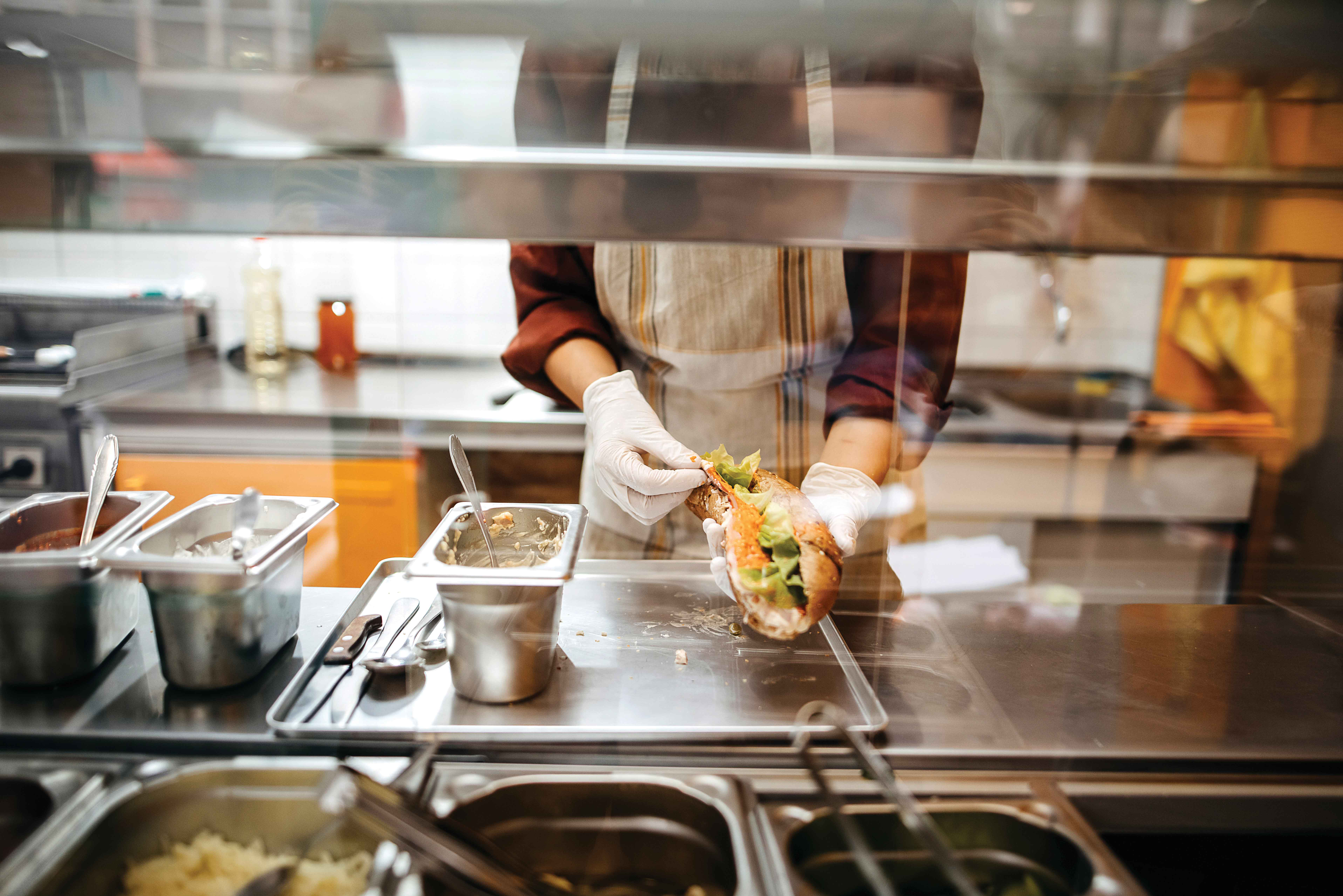 Picture of an employee making a sandwich in a store